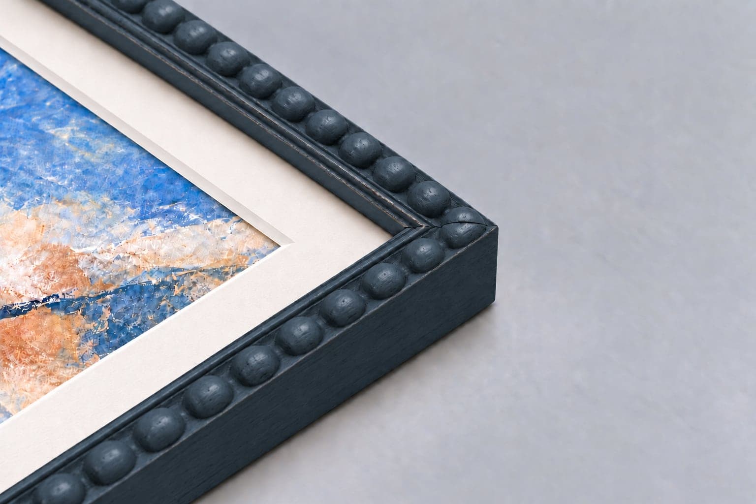 Corner detail of a midnight blue bobbin frame with a mount